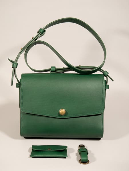 Sac à main ICONIK taille M en cuir vert sapin sur fond photo gris