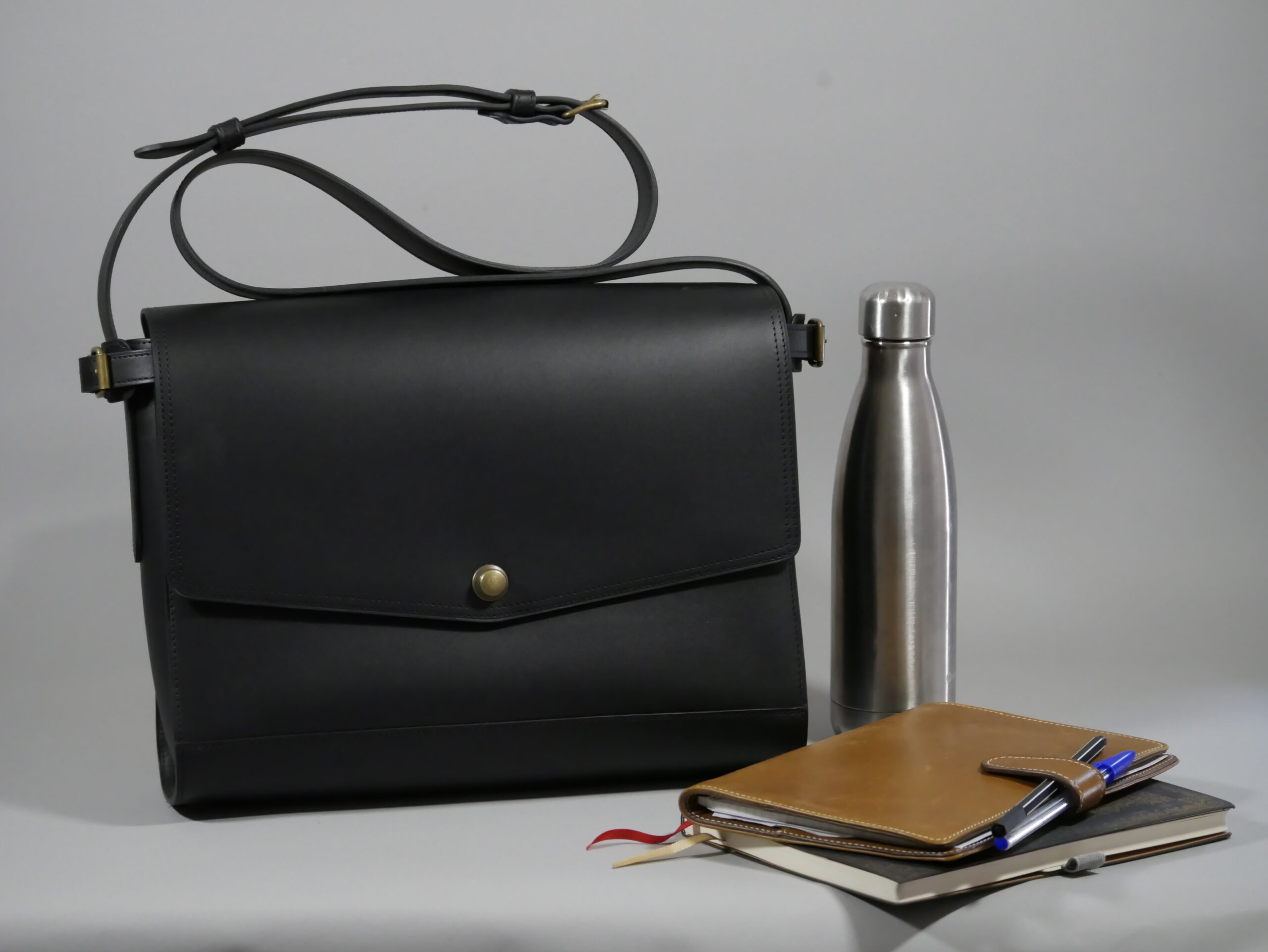 sac Iconik XL noir et ses possibilités de contenance :gourde, agenda, carnets