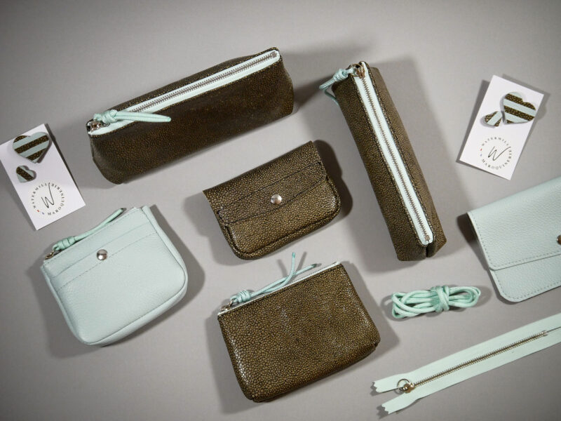 Accessoires Capsule Watermill — famille Berlingot en trois tailles : porte-monnaie XS, trousse S et grande trousse M, trousse élastique, clutch et pin's, en croûte de cuir gris façon galuchat et zip contrasté cyan et porte-monnaie zippé cyan