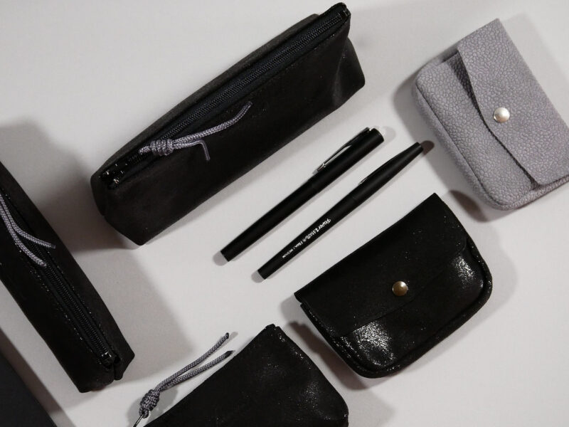 Accessoires Capsule Watermill — famille Berlingot: détail berlingot taille m en croûte de cuir noir pailleté, présenté avec clutch , et berlingot taill xs