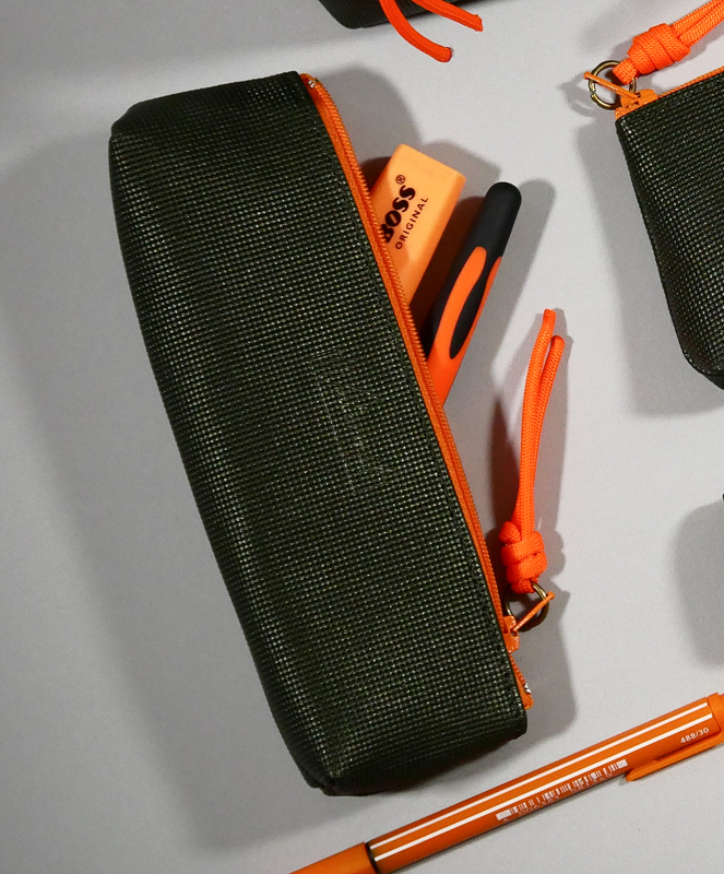 trousse berlingot taille s, cuir graphique kaki zip contrasté fluo orange présenté avec accessoires coordonnés collection capsule