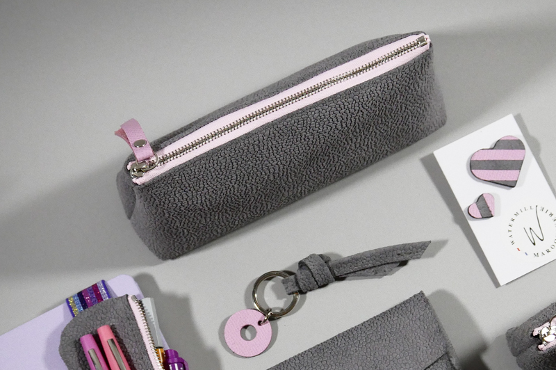 grande trousse berlingot taille M, en croûte de cuir gris clair grainé zip contrasté rose pastel présenté avec accessoires coordonnés, collection capsule