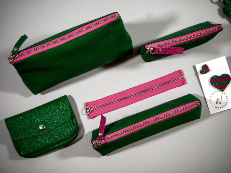 Accessoires Capsule Watermill — famille Berlingot en trois tailles : porte-monnaie XS, trousse S et grande trousse M, et clutch en cuir vert émeraude grainé et zip contrasté fushia