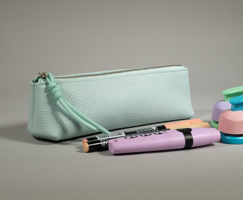 trousse longue berlingot s en cuir cyan grainé présentée avec des feutres pastels